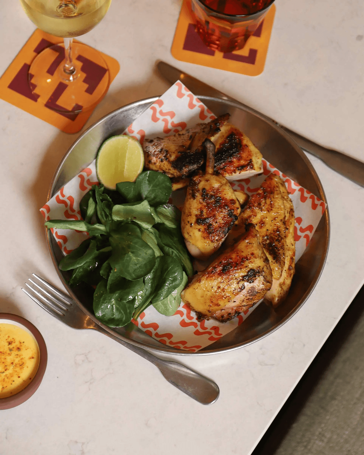 Bowl of marinated chicken thighs with salad.